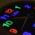 Fémkeretes analóg quartz falióra színes LED számlappal, 25.5 cm